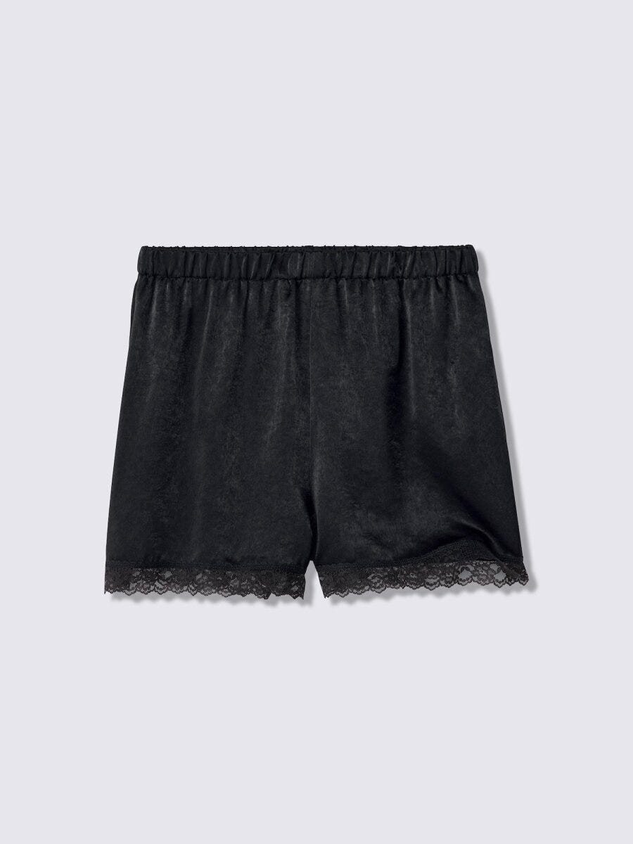 黒いサテン生地のショートパンツ。裾に黒いレースがあしらわれている。