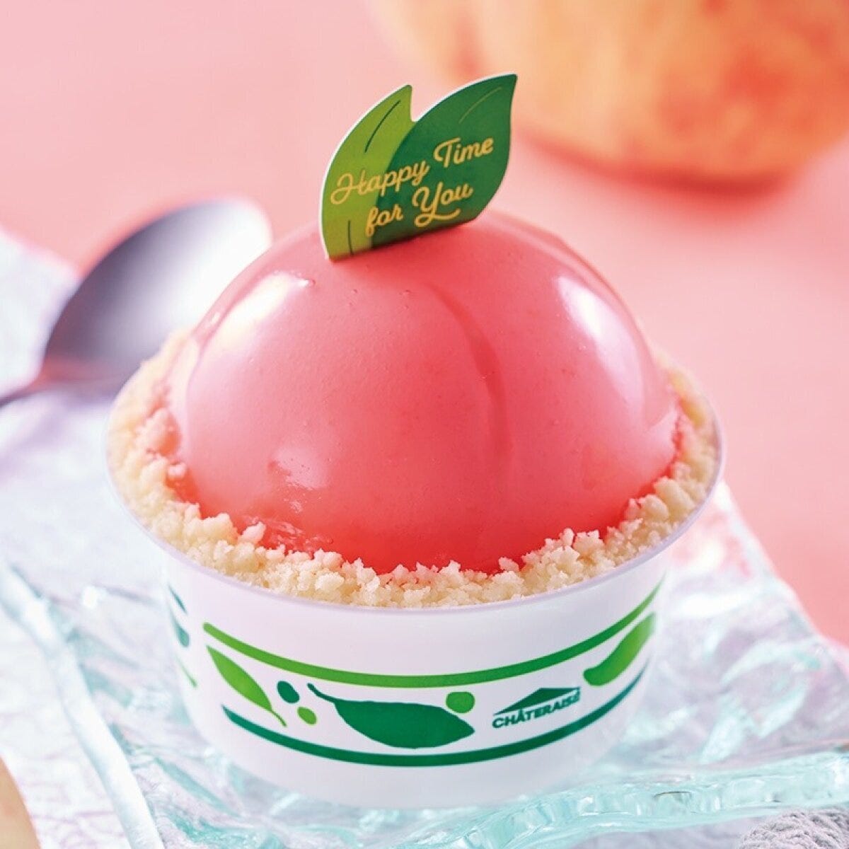 ピンク色の桃を模したカップ入りケーキ、葉の飾り付き ピンク色の桃を模したカップ入りケーキ、葉の飾り付き