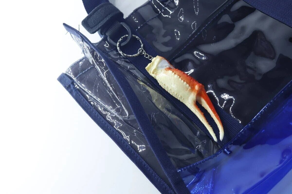 青いビニールバッグのポケットにカニ爪キーホルダーが付いている