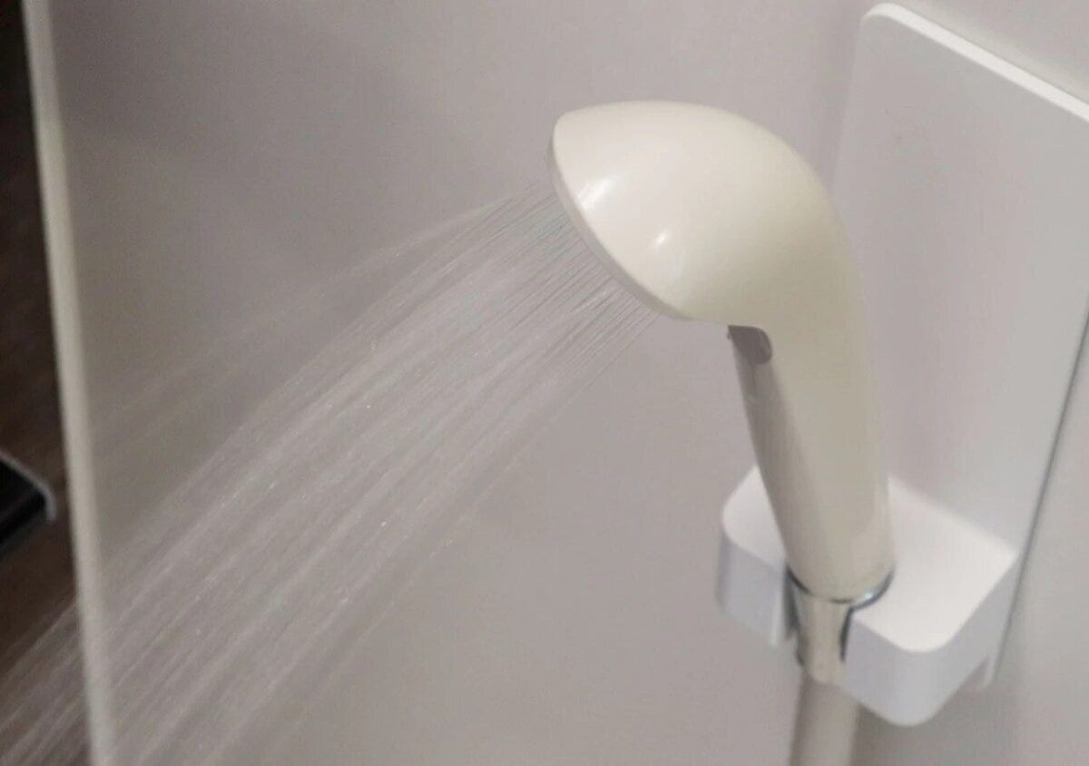 マグネットホルダーに固定されたシャワーから水が出ている