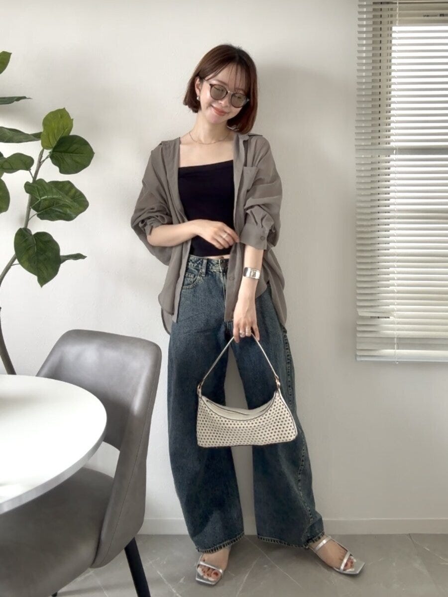 カーキのシアーシャツと3Dバレルジーンズを着て立つ女性 カーキのシアーシャツと3Dバレルジーンズを着て立つ女性