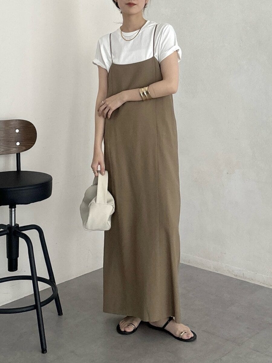 白Tシャツとブラウンキャミワンピの女性、白い巾着バッグとサンダル