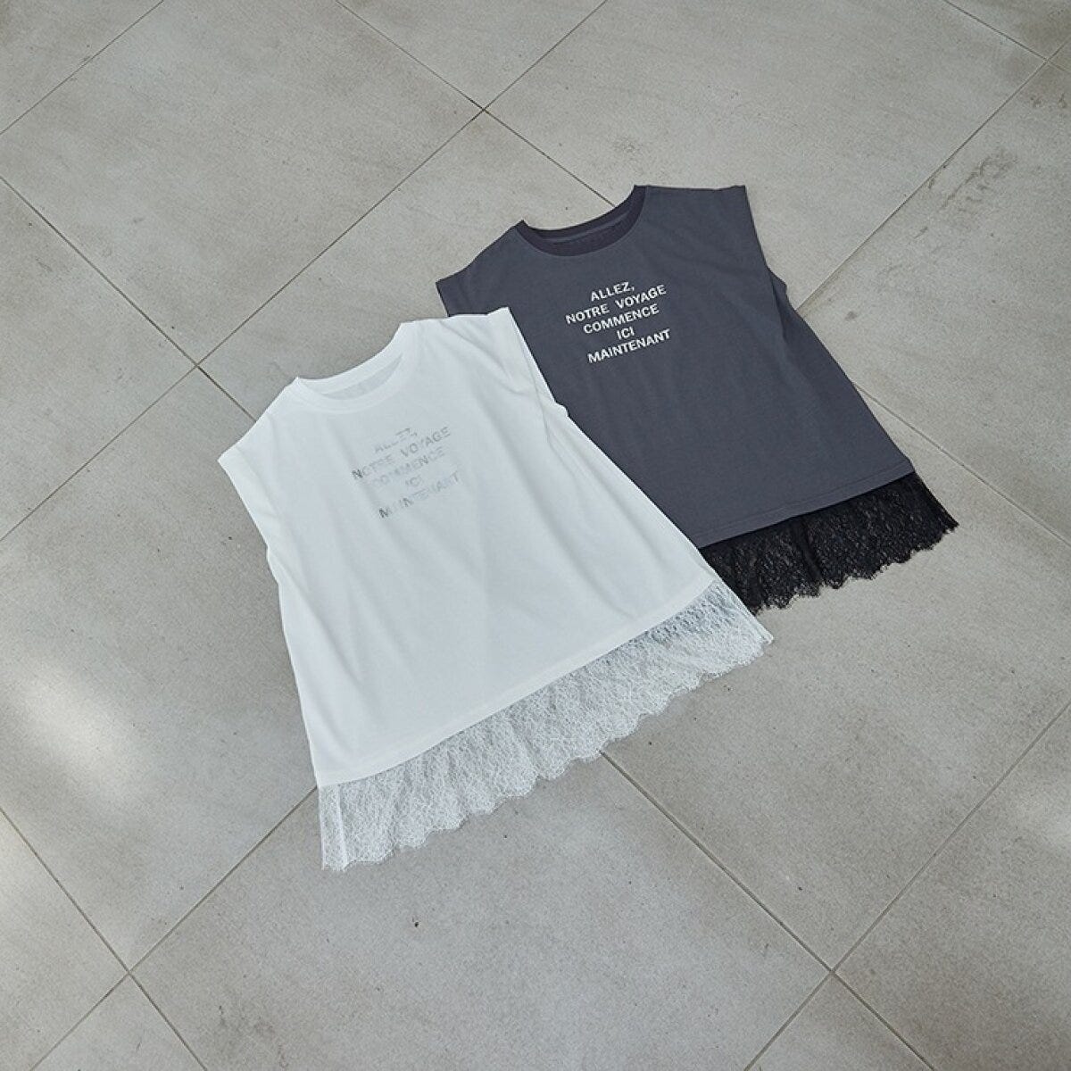白とグレーのレース裾ロゴTシャツが床に並べられている