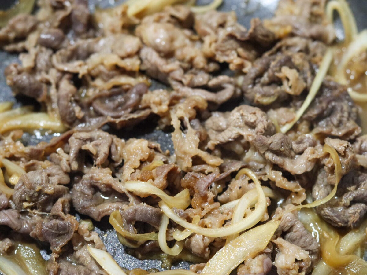 フライパンで牛肉と玉ねぎが炒められ、火が通り茶色く煮詰まっている様子 フライパンで牛肉と玉ねぎが炒められ、火が通り茶色く煮詰まっている様子