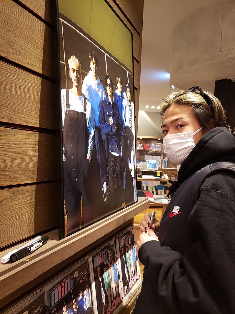 サインを書くコムドットメンバー（画像提供：宝島社）