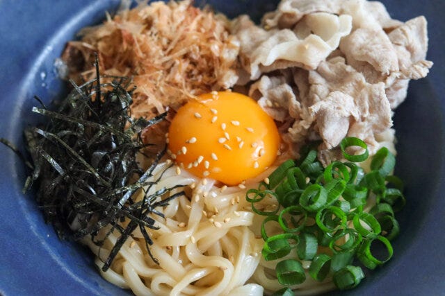 真ん中に卵黄をのせて、豚肉、かつお節、万能ねぎ、刻み海苔をまわりにトッピングし、白いりごまをふって、ラー油と酢をお好みでまわしかける。 真ん中に卵黄をのせて、豚肉、かつお節、万能ねぎ、刻み海苔をまわりにトッピングし、白いりごまをふって、ラー油と酢をお好みでまわしかける。