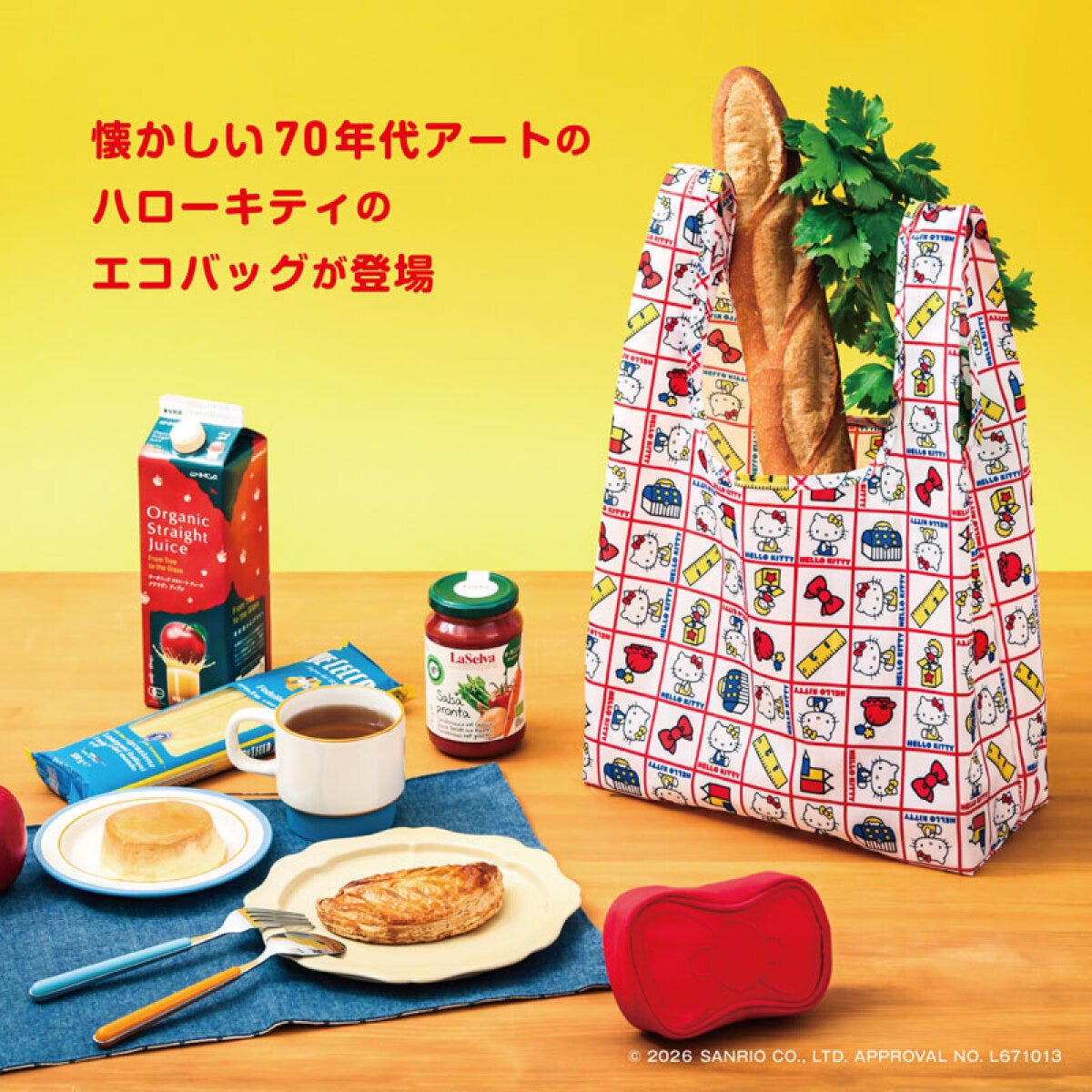 ハローキティのレトロ柄エコバッグと赤いリボンポーチ 黄色い背景の食卓に置かれた、赤い格子柄に70年代風ハローキティのイラストが並ぶエコバッグ。バゲットや野菜が入り、手前に赤いリボン型ポーチも