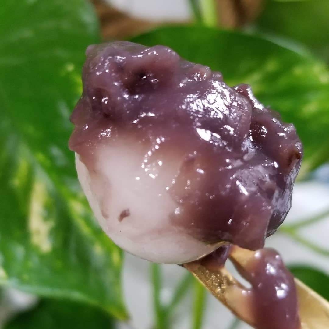 ひとくち白玉の冷やしぜんざいの少しの小豆と白玉をすくっている写真