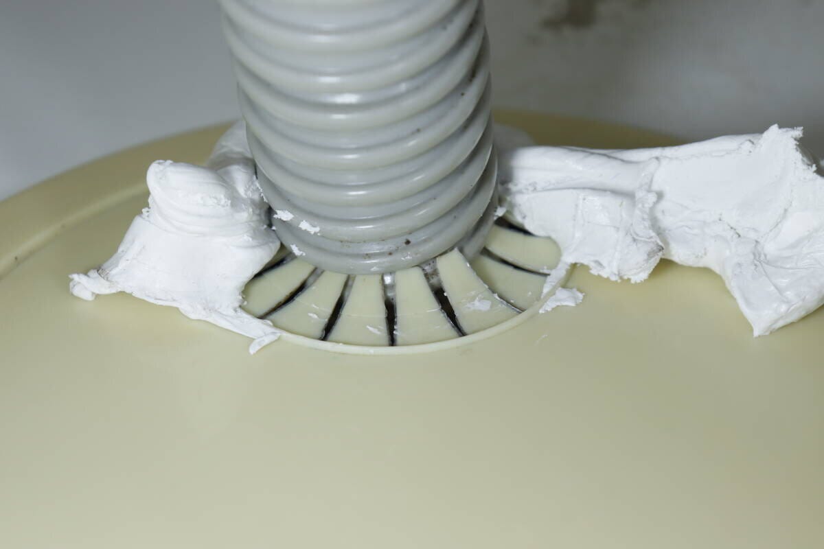 洗濯機の排水ホースと床の隙間に白いすきまパテを充填した直後の状態 洗濯機の排水ホースと床の隙間に白いすきまパテを充填した直後の状態