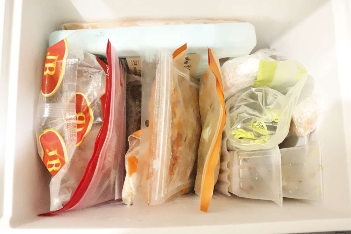 フリーザーエンドを使って冷凍食品が立てて整理され、すっきりした冷凍庫の中 フリーザーエンドを使って冷凍食品が立てて整理され、すっきりした冷凍庫の中