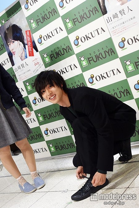 シャッターに気づき照れ笑い