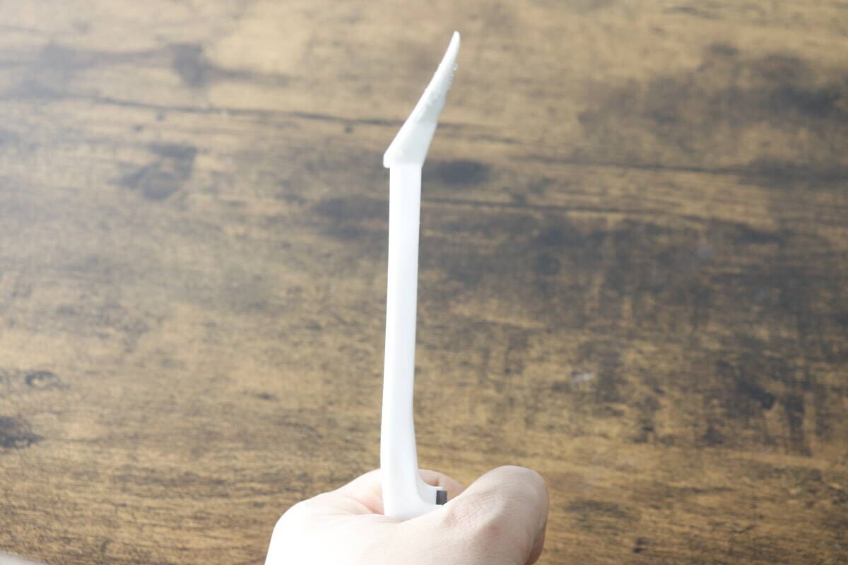 手で持った白い水切りワイパーの側面。ブレード部分がしなっている様子がわかる 手で持った白い水切りワイパーの側面。ブレード部分がしなっている様子がわかる