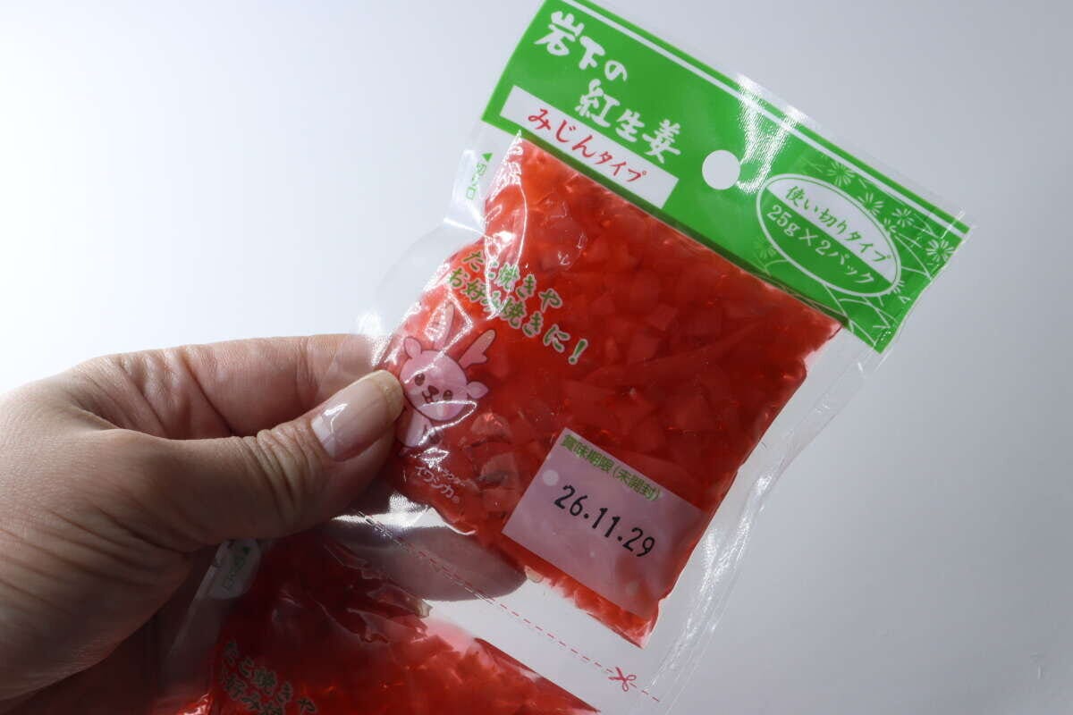 女性の手が岩下の紅生姜みじんタイプの小分けパックを一つ持っている
