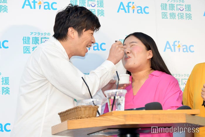 よしこ(右)に激苦健康卵豆腐を“あ~ん”する田中圭(左)/(C)モデルプレス
