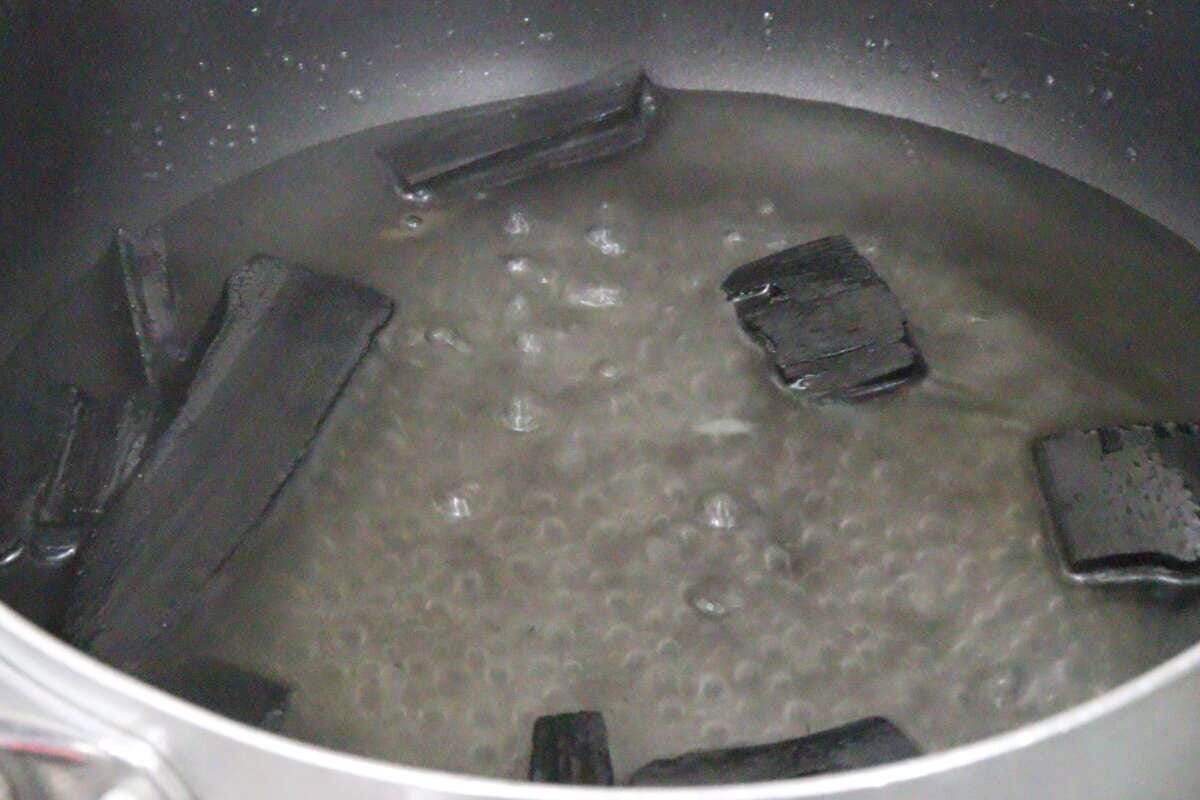 鍋で竹炭を煮沸消毒している様子、水が沸騰している
