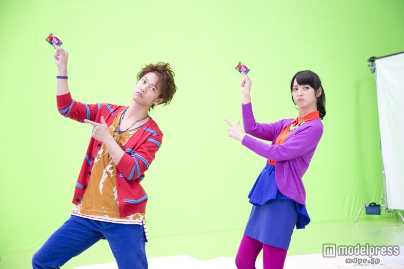 怪訝な表情から瞬時に笑顔になる佐藤健(左)、佐々木希(右)/ロッテ「Fit’s(裏切り果実)」新CM『裏切り果実』篇メイキングカットより