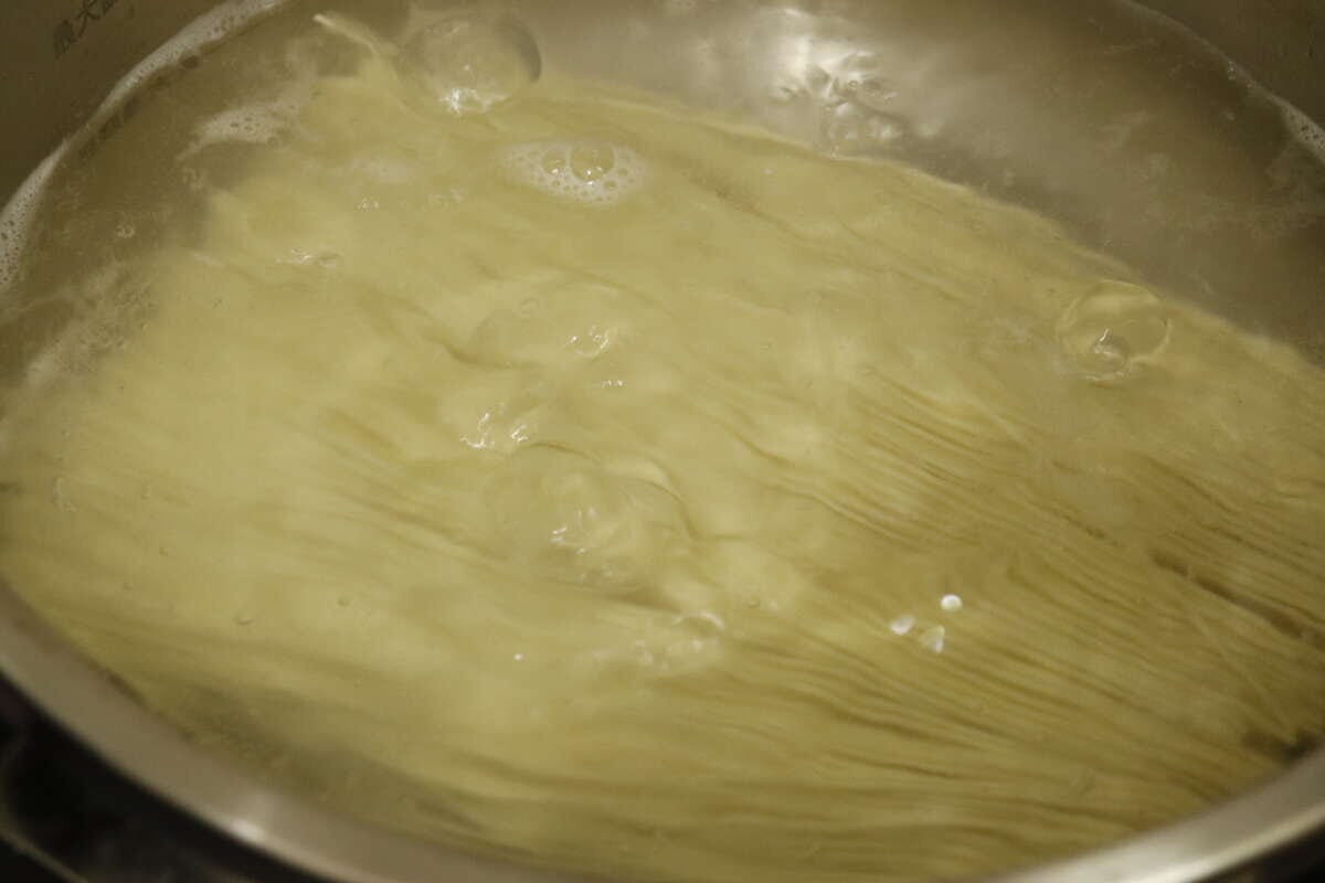 鍋の中で沸騰したお湯で棒ラーメンの麺が茹でられている様子 鍋の中で沸騰したお湯で棒ラーメンの麺が茹でられている様子