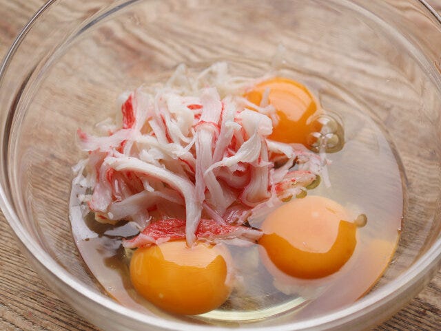 ボウルに卵と手で裂いたカニカマをいれ、菜箸などで混ぜる。
