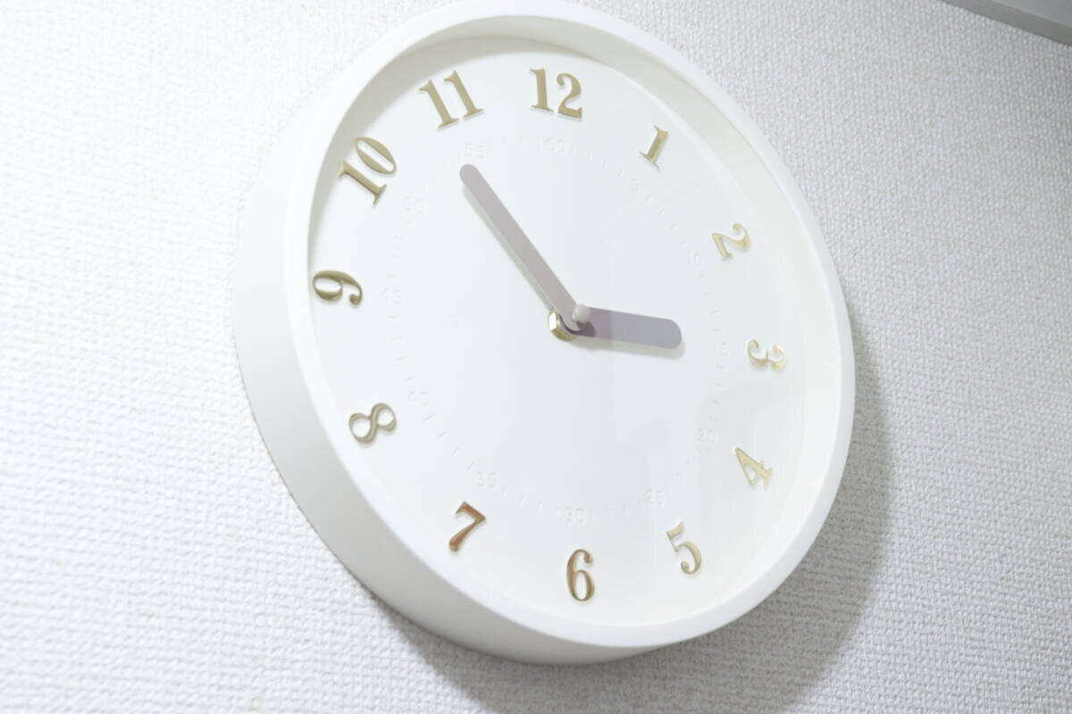 白い壁に掛けられたダイソーの白い掛け時計の全体像