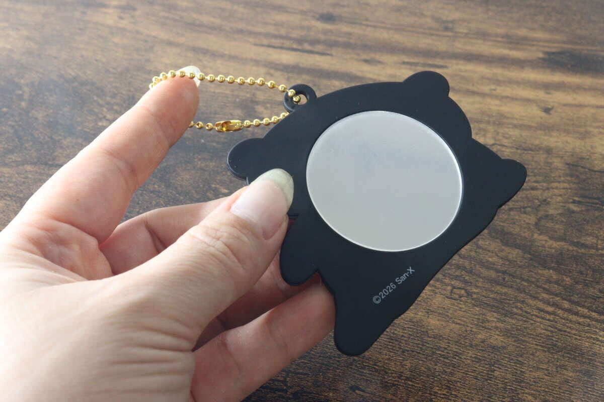 キーホルダーの裏面にある丸いミラーを手に持って見せている状態 キーホルダーの裏面にある丸いミラーを手に持って見せている状態