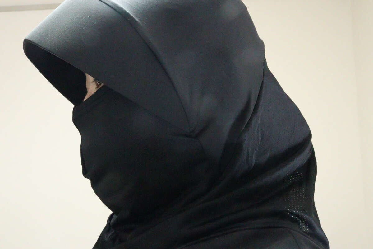 黒いフェイスガードを着用した人物の横顔。目元だけが見えており、顔全体が覆われている 黒いフェイスガードを着用した人物の横顔。目元だけが見えており、顔全体が覆われている