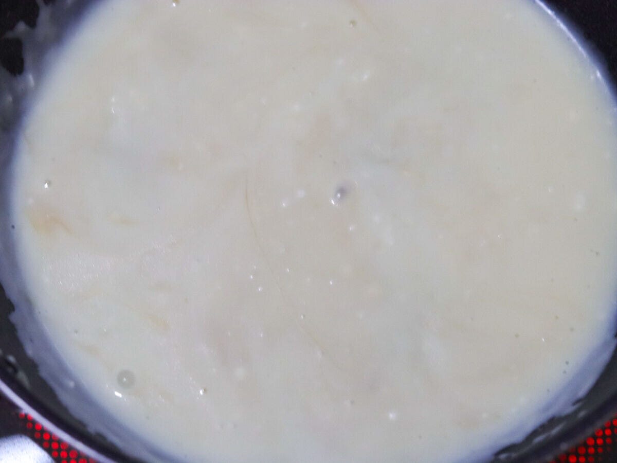 フライパンでとろみがついた白いクリームソースが煮立っている様子 フライパンでとろみがついた白いクリームソースが煮立っている様子