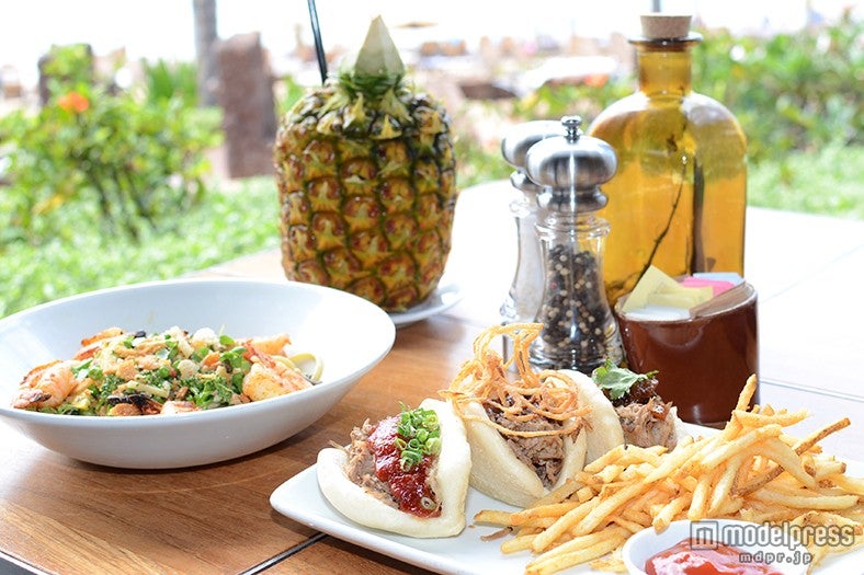 （左から）ブカティーニのプリマベーラパスタ 地元産のエビ添え（＄24）、カルア風ローストポークのライスバーガー（＄16）