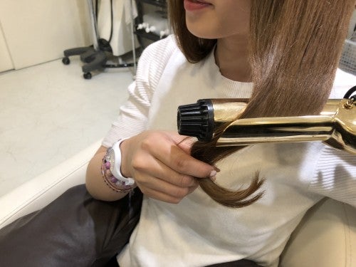 外ハネにした毛束を優しく手にとり、その上に内巻きをしてウェーブを作っていきます。