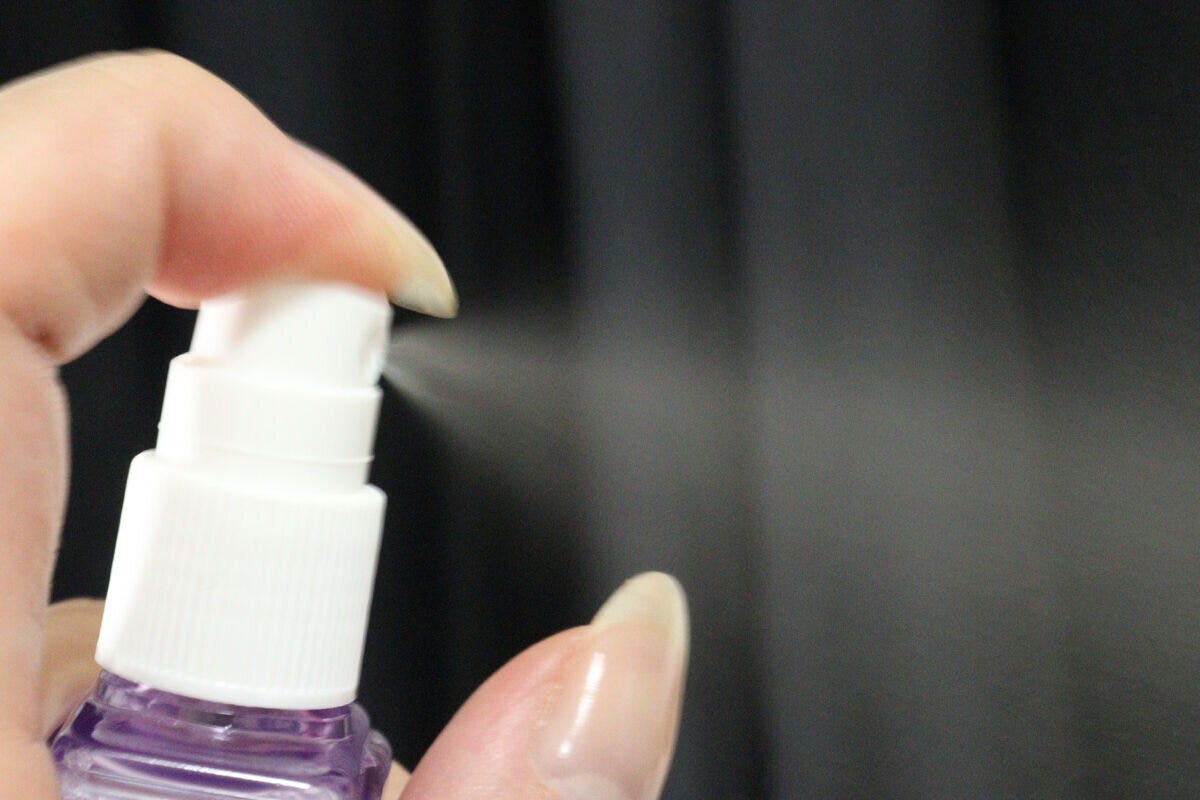 女性がクロミミストボトルを噴射し細かいミストが出ている 女性がクロミミストボトルを噴射し細かいミストが出ている