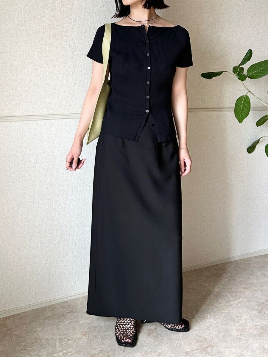 黒カーデと黒ロングスカート、緑バッグの女性 黒カーデと黒ロングスカート、緑バッグの女性