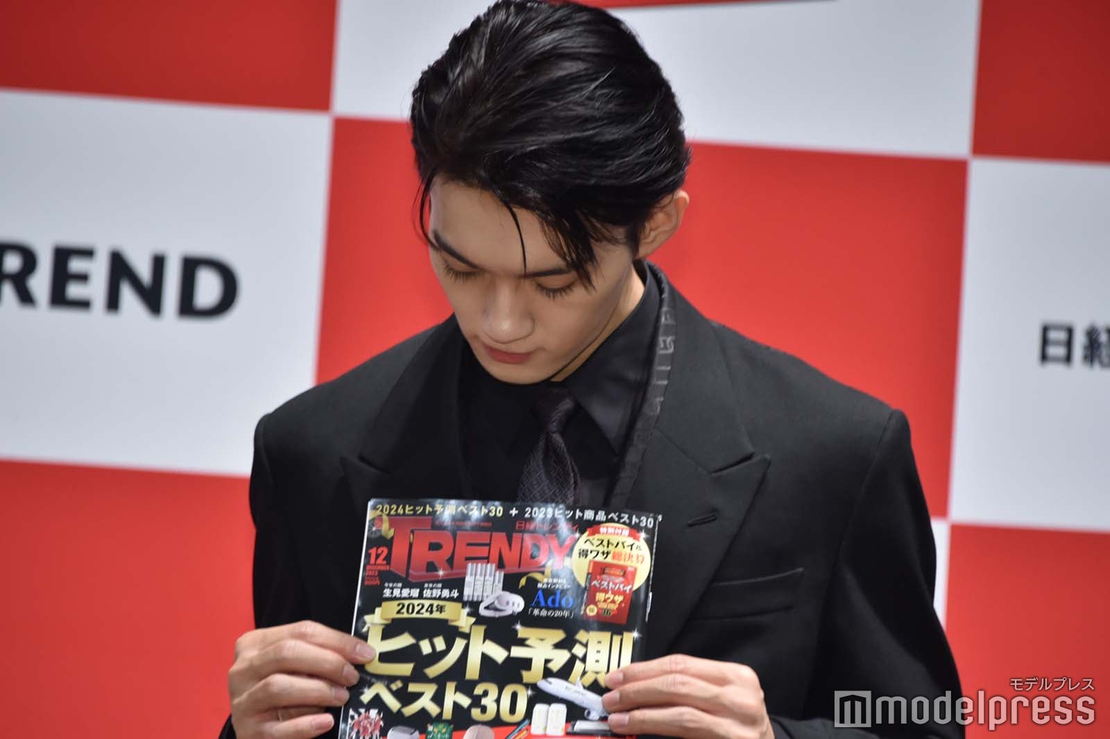 雑誌をじっと見つめる佐野勇斗（C）モデルプレス