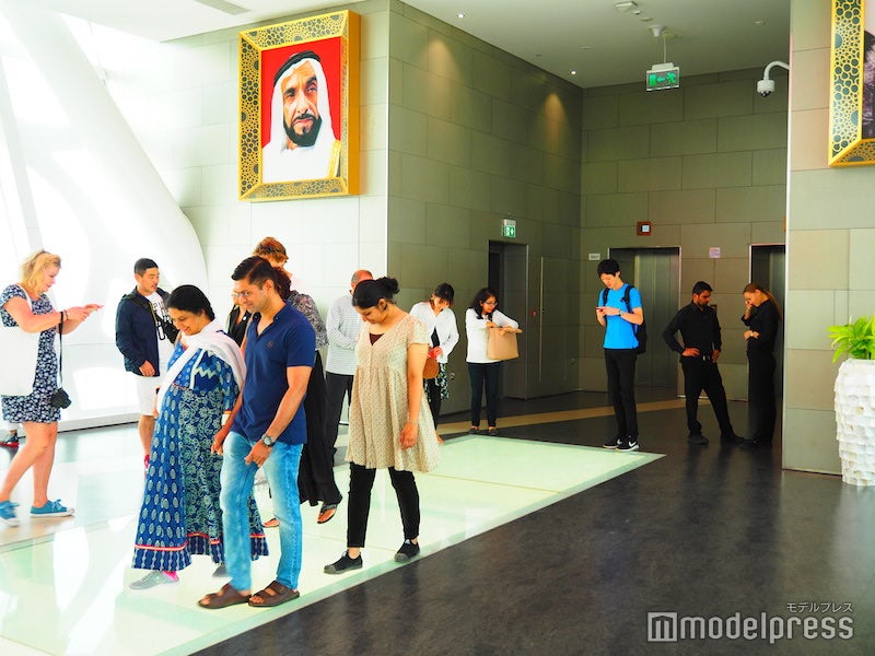 ガラス張りの床を覗きながら歩く観光客たち（C）モデルプレス