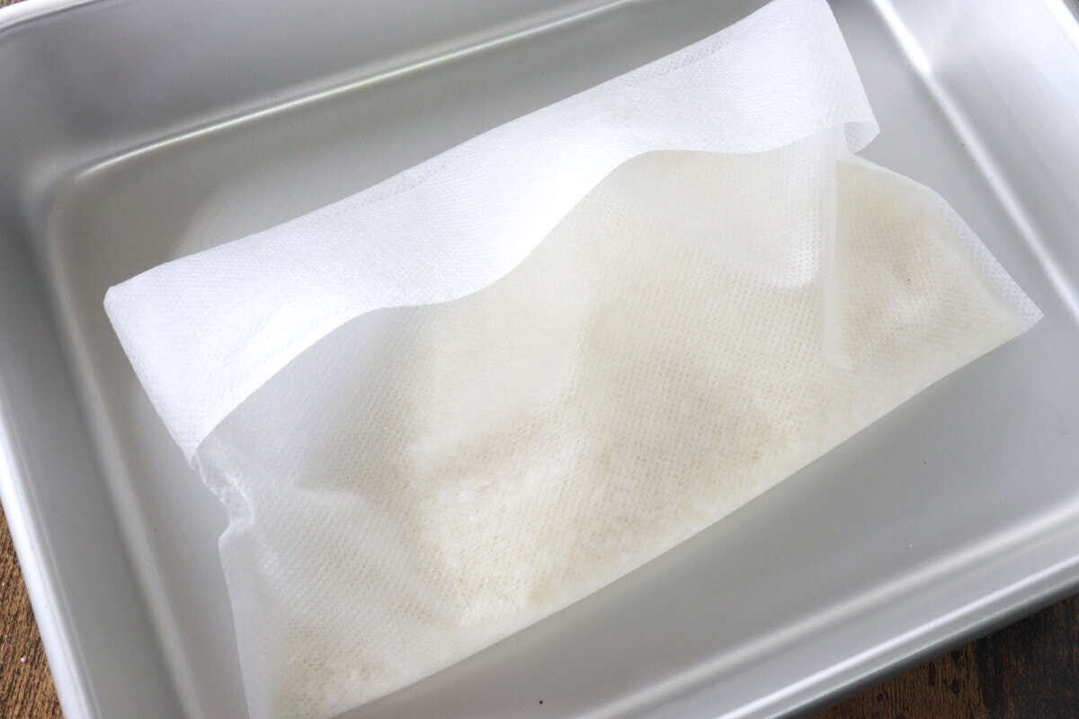 口を折り返して中身が出ないようにした炊飯袋をトレーに置いた俯瞰写真 口を折り返して中身が出ないようにした炊飯袋をトレーに置いた俯瞰写真