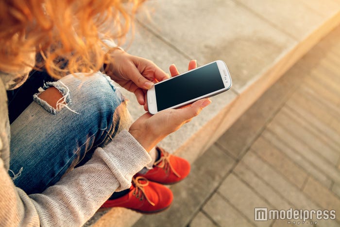下を向いてのスマホ操作は“たるみ”の原因に(photo by determined/Fotolia)