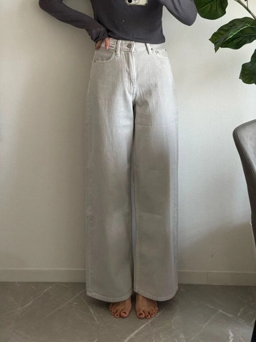 ライトグレーのハイライズワイドジーンズを着用した女性