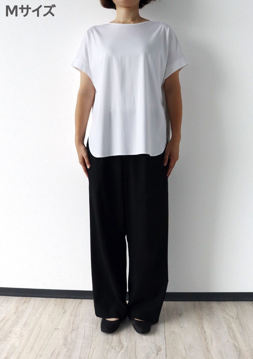 女性がPLSTのMサイズ白Tシャツと黒パンツを着用し正面で立つ