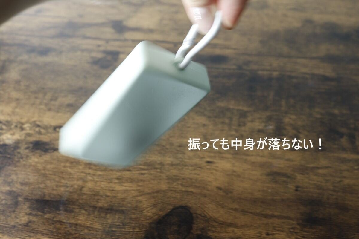 中身が入ったケースを振っても落ちないことを示す手元 中身が入ったケースを振っても落ちないことを示す手元