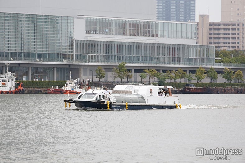 信濃川の河口から船に乗って登場（C）AKS