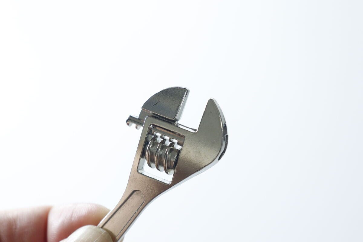 指でモンキーレンチのキーホルダーの調整部分を回す