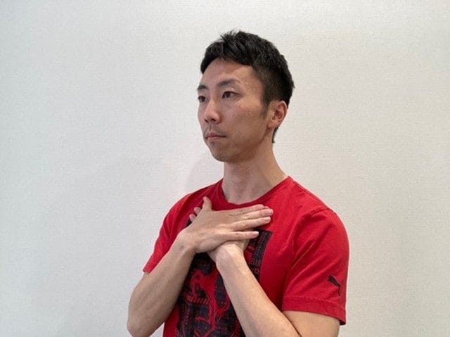 鎖骨を両手で押さえる
