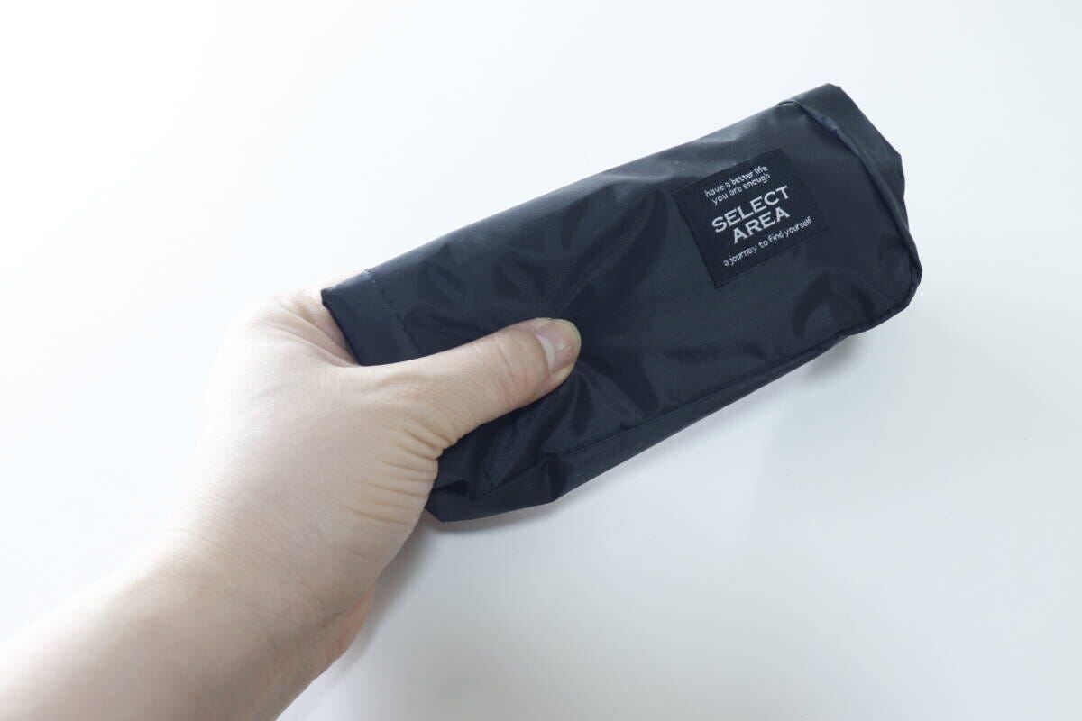 黒いショルダーバッグをコンパクトに折りたたみ片手で持つ