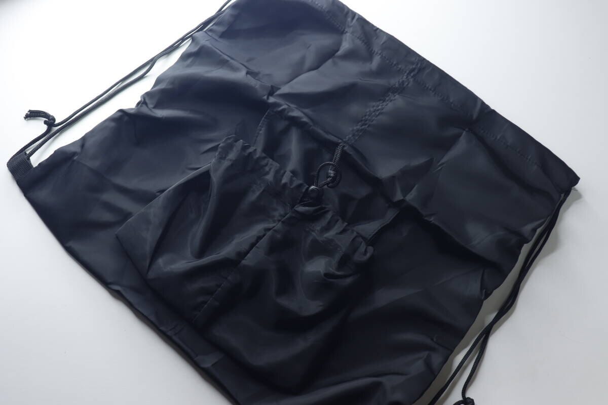 広げた黒いナップサックと収納袋がポケットになった状態