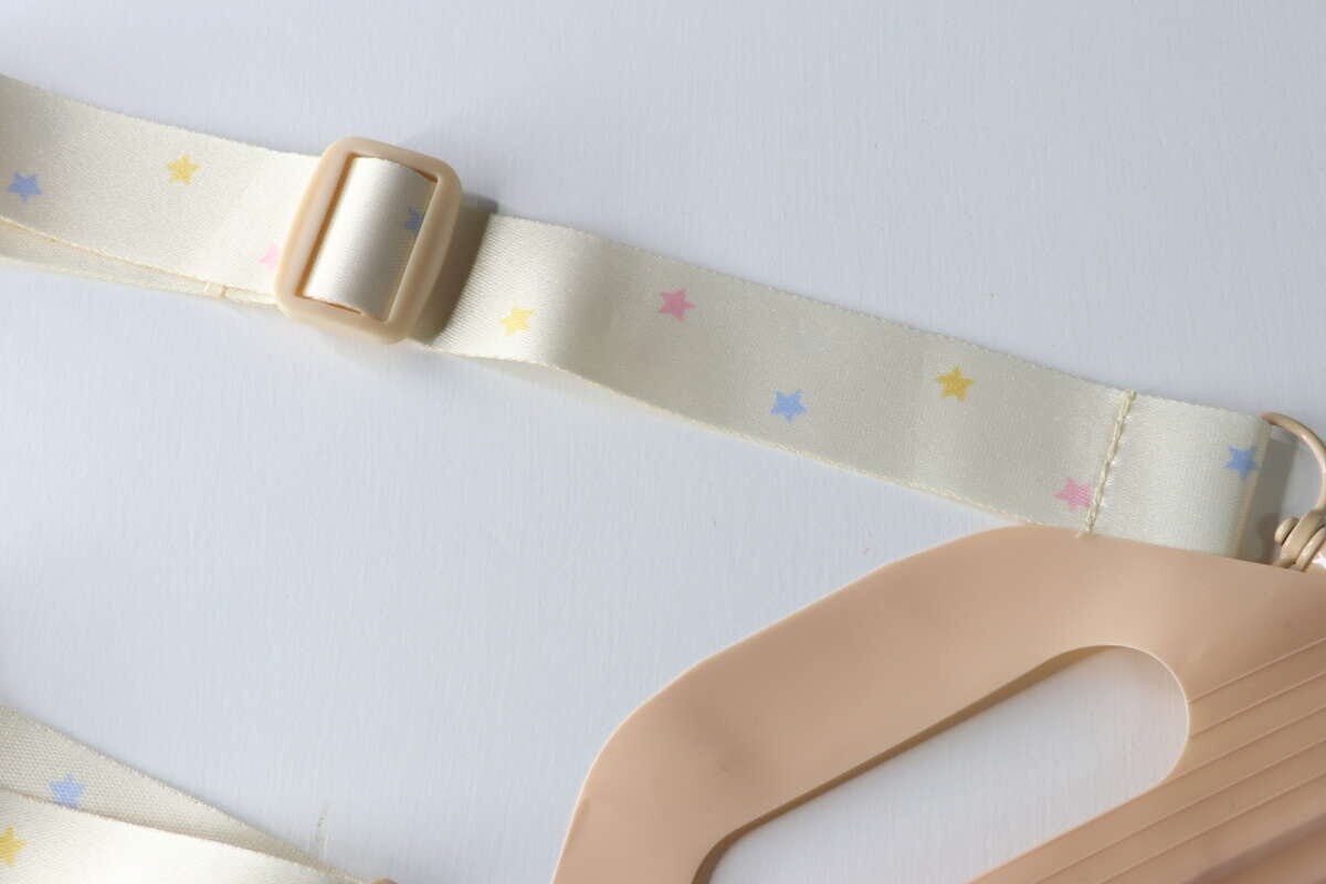 星模様が散りばめられた淡い色のストラップと長さ調節パーツの接写