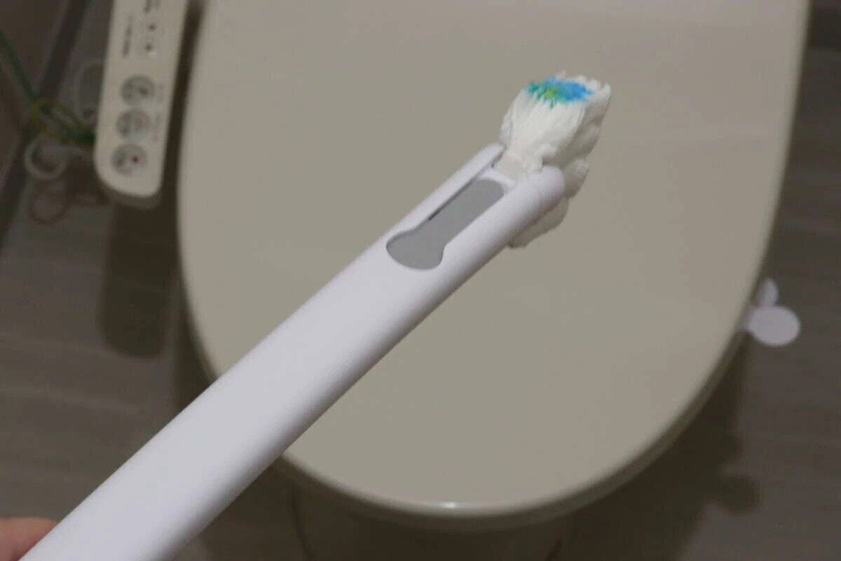 トイレを背景に、洗剤付きブラシが装着されたクリーナーハンドル トイレを背景に、洗剤付きブラシが装着されたクリーナーハンドル