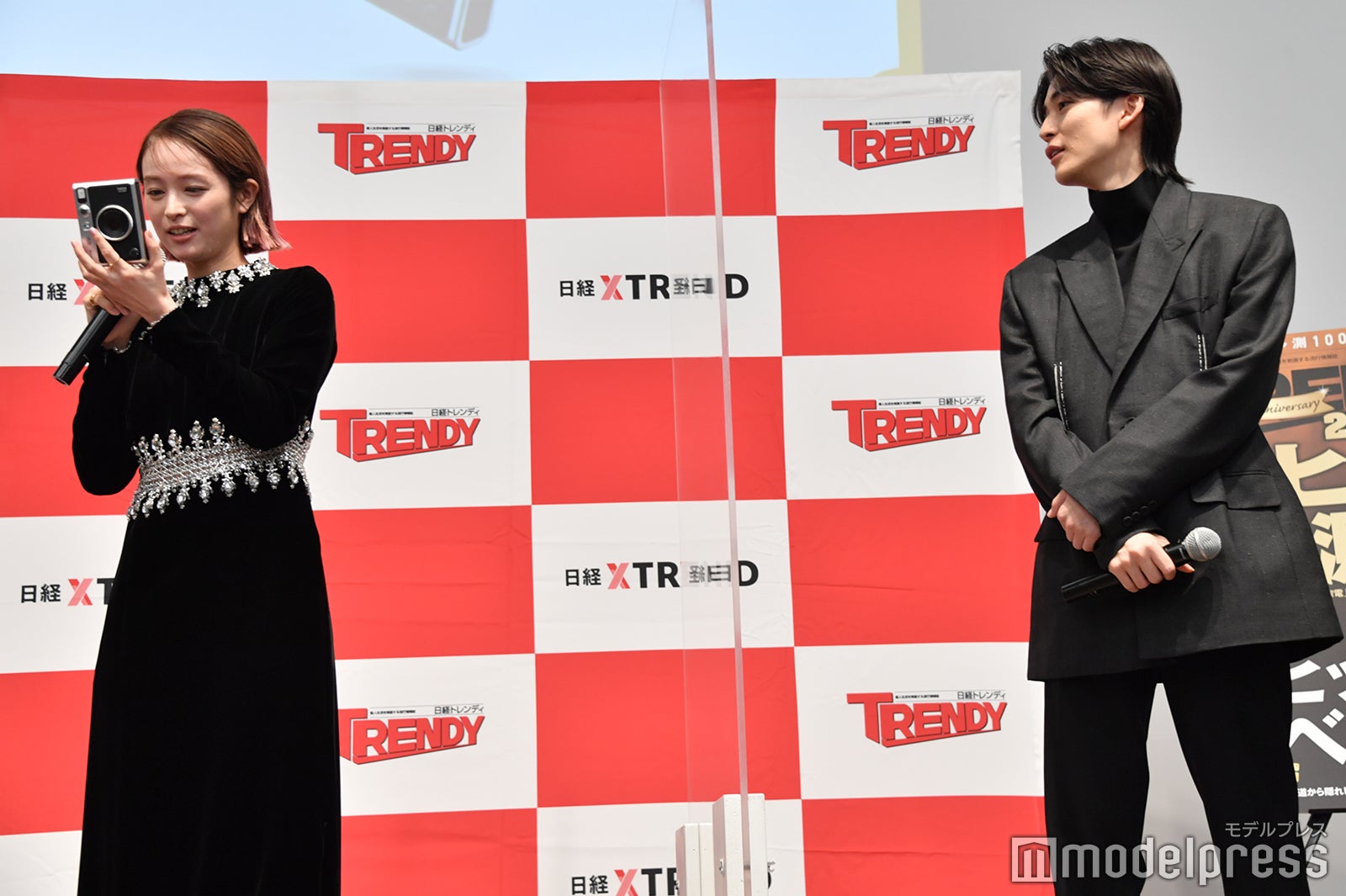 清野菜名の持つカメラが気になる様子の高橋文哉（C）モデルプレス