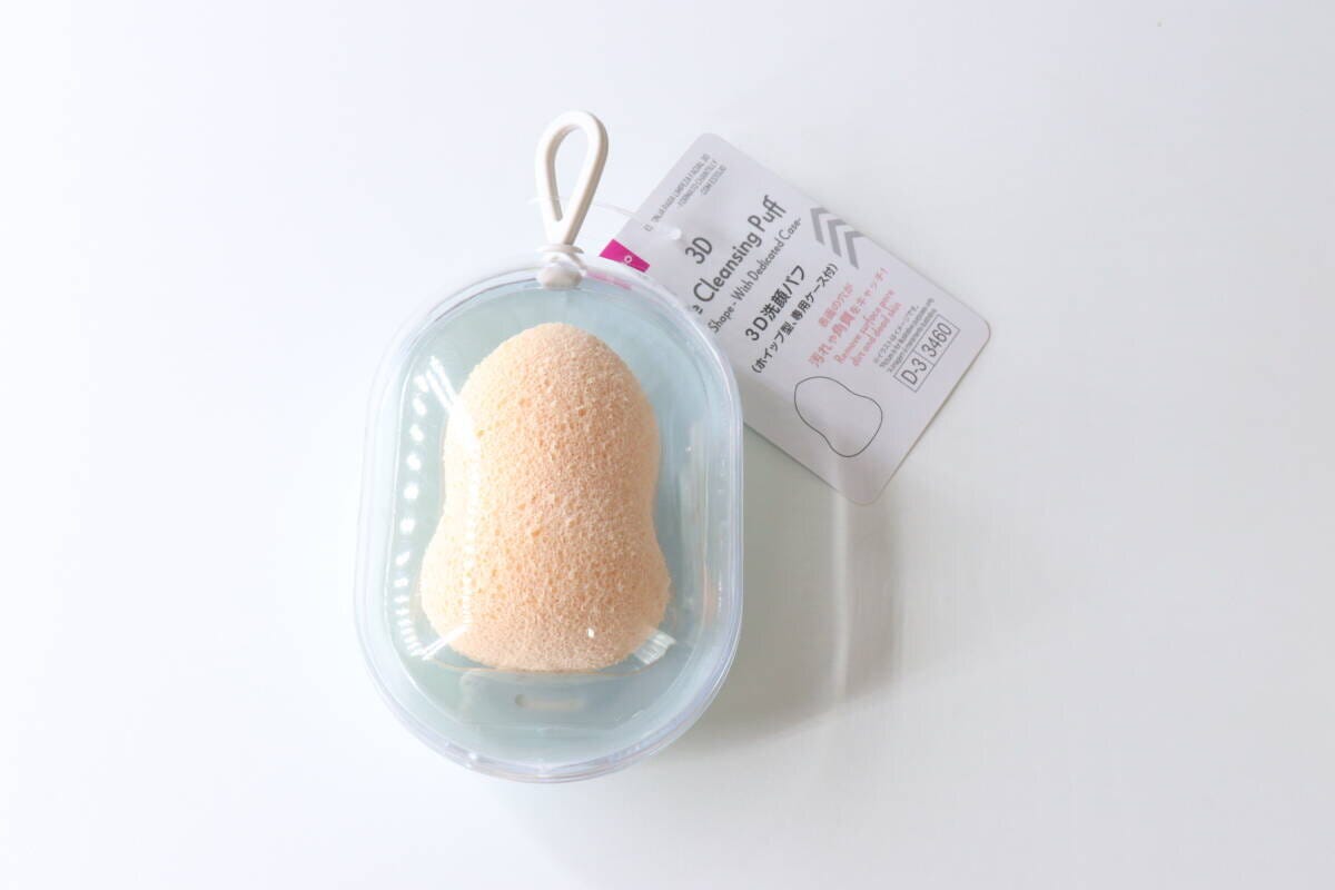 透明なケースに入ったひょうたん型の洗顔パフと商品タグ