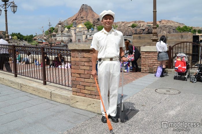 ヒントを伝える、オレンジのほうきを持ったカストーディアルキャスト/謎解きプログラム「とらわれたピノキオを救い出せ!」