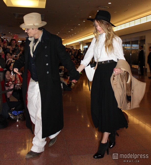 手をつないで空港を歩くふたり。