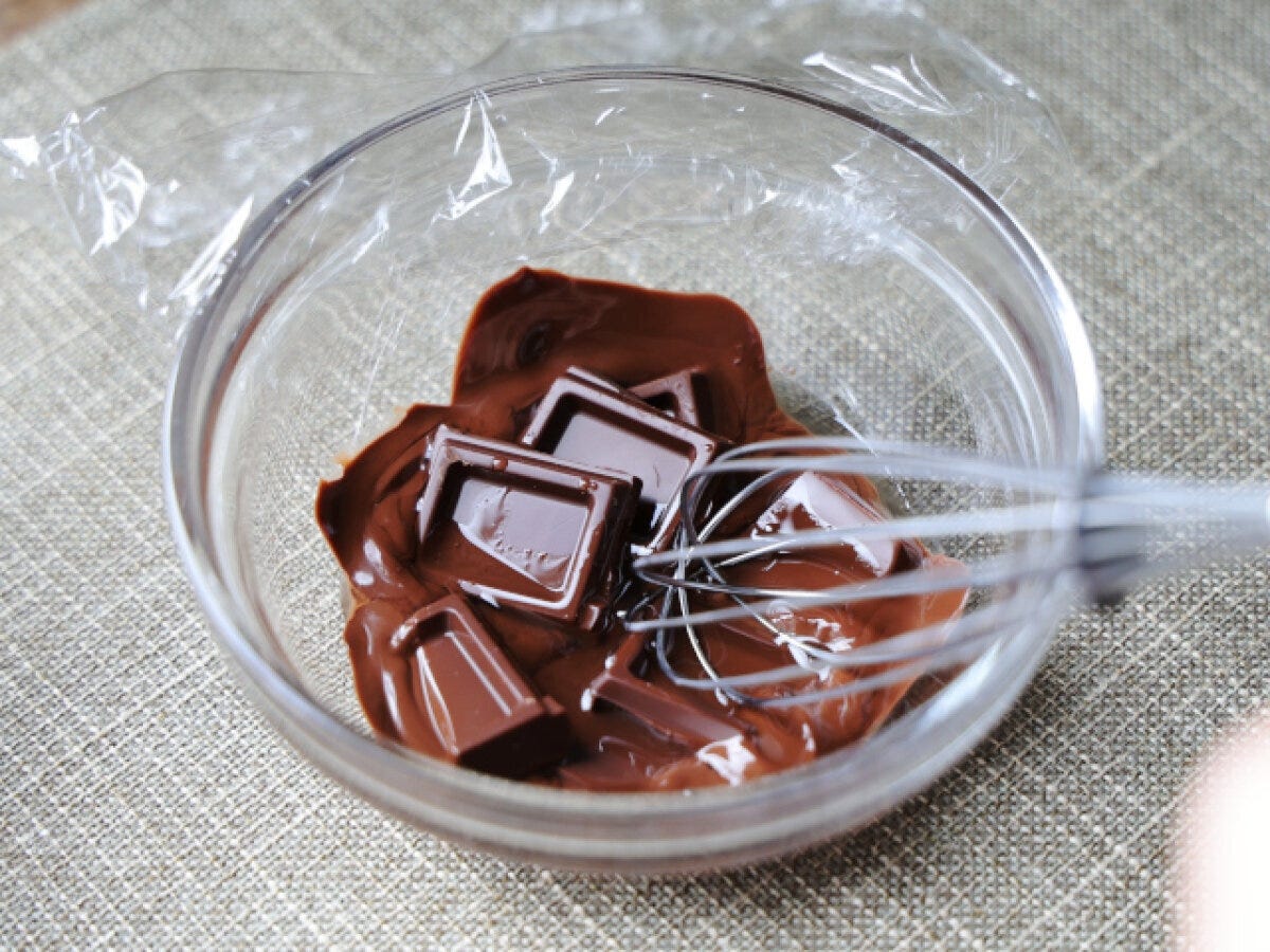 透明な耐熱ボウルに割ったダークチョコレートとこめ油が入っており、泡立て器が添えられている。