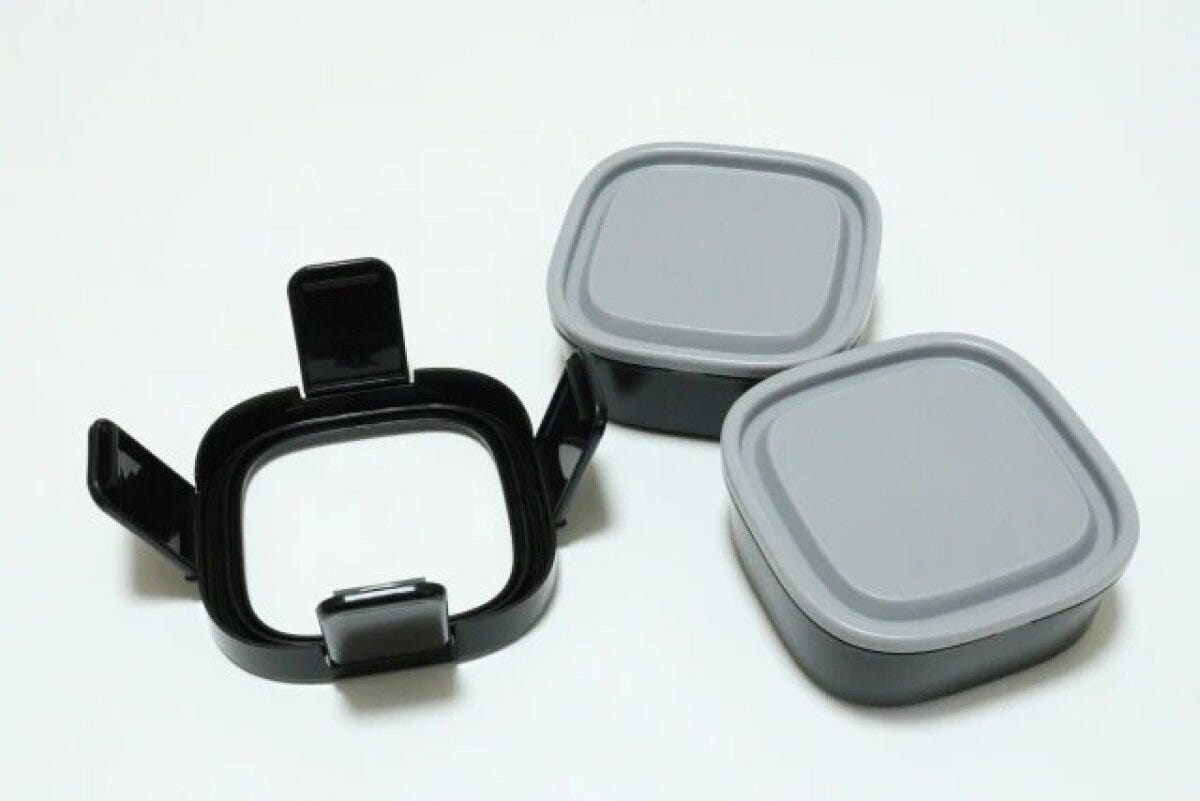 黒いロックフレームと灰色蓋付き容器2つに分解されたランチボックスのパーツ一式